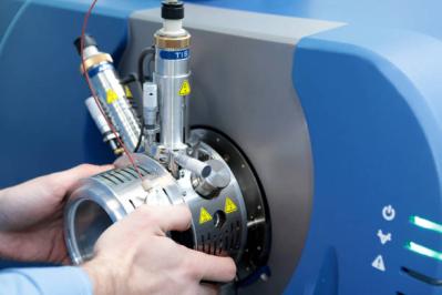 Adjust the mass spectrometer. The man analyzes the device for determining the masses of atoms. Device for the pharmaceutical industry. Ionic source of mass spectrometer.